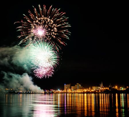 Long Exposure of Fireworks Reflecting on Calm Rippling Waterの写真素材