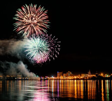 Long Exposure of Fireworks Reflecting on Calm Rippling Waterの写真素材