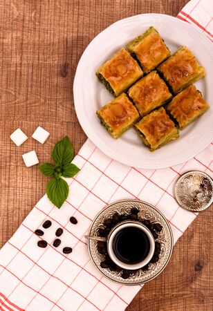 Turkish delights - baklava traditional sweets with turkish coffee, sugar the view from the top on wooden table and white fabricの写真素材