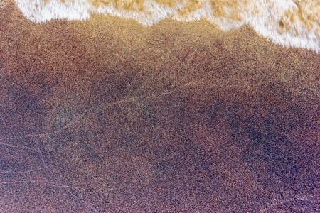 closeup of wet colorfull sand pattern of a beach