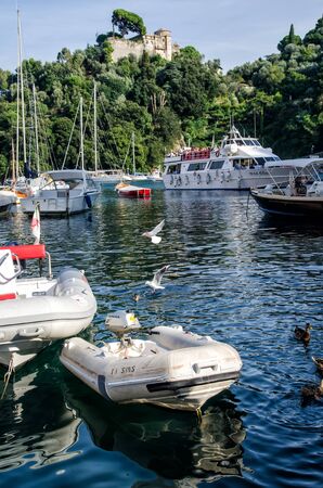 Italy, Portofino - October 3, 2014: Boats on water in the picturesque bay of Portofino with the view over the colorful housesのeditorial素材