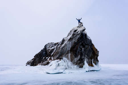 Lake Baikal, Russia - March 9, 2020: Rock climber on the top of mountain island. Sport and active lifeのeditorial素材