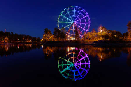 Russia, Irkutsk - June 13, 2020: Colorfull abstract Ferris wheel with reflection on the Konny island in Irkutsk at nightのeditorial素材