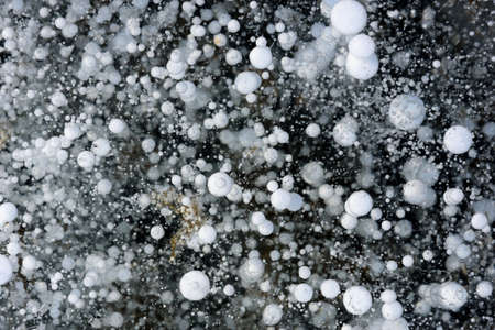 Beautiful ice of Lake Baikal with abstract cracks and frozen air bubblesの写真素材