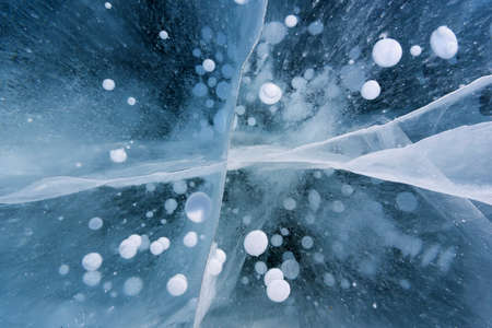 Beautiful ice of Lake Baikal with abstract cracks and frozen air bubblesの写真素材