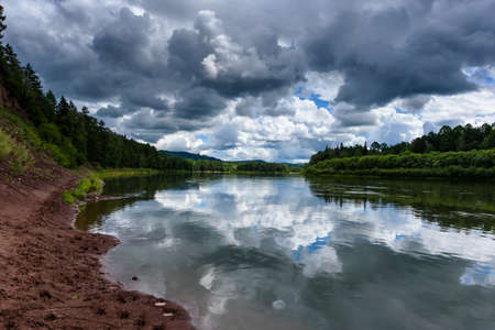 Irkut river with a quiet current and clouds reflection, Eastern Siberia, Russiaの写真素材