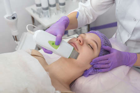 Beauty salon. The cosmetologist makes a water peeling procedure for the client. Side view. The...