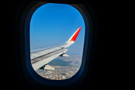 Looking through window aircraft during flight in wing lands over Istanbul in sunny weatherの写真素材