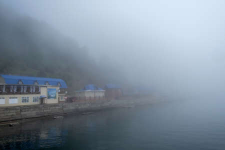 Peaceful scene of lake Baikal with pier on water at morning with fogの写真素材