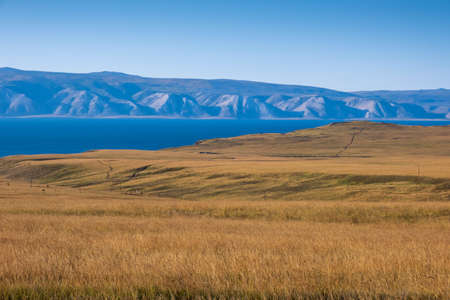 Lake Baikal and mountains of Siberia with blue clear sky and yellow dry grass in autumn peaceful day, Russia Oklhon islandの写真素材