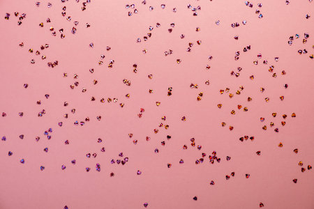 Pink pastel background with small hearts confetti. Flatlay, top view, copy spaceの写真素材