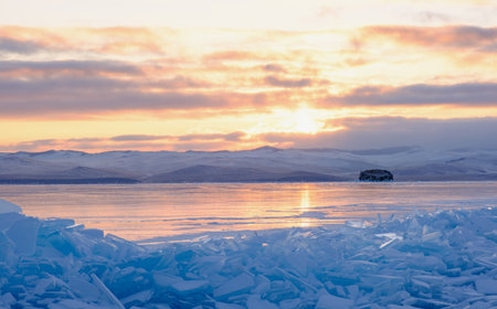 Lake Baikal in winter covered with ice and snow texture in sunset evening, Russia, Siberia