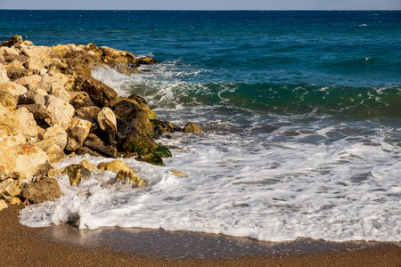 Sea wave breaks on sandy beach with clouds sky on Mediterranean coast of Mersin province, Atakentの写真素材
