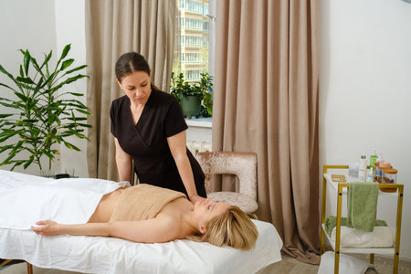 Massage therapist gives woman oil massage.の写真素材