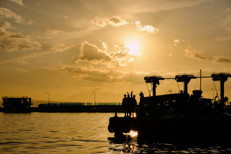 Erdek, Turkey - February 8, 2024 : Erdek Town harbor with ships at sunset