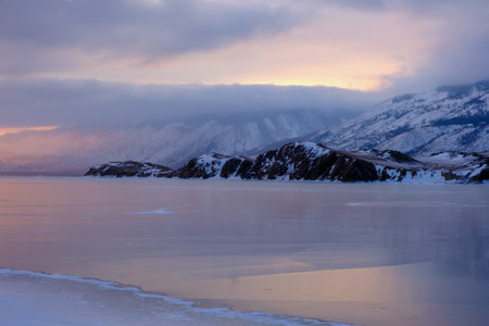 Baikal Lake in winter. Beautiful landscape with mountains reflected in ice of frozen Small Sea