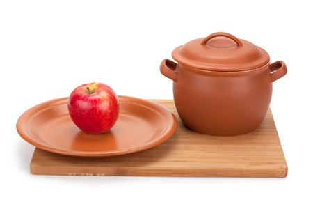 apple and earthenware crockery on a cutting board isolated on white backgroundの写真素材