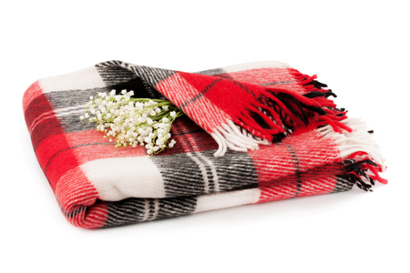 Checkered warm blanket and a bouquet lilies of the valley isolated on white background.の写真素材