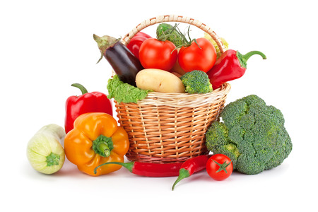 fresh and ripe vegetables arranged in a basket isolated on whiteの写真素材