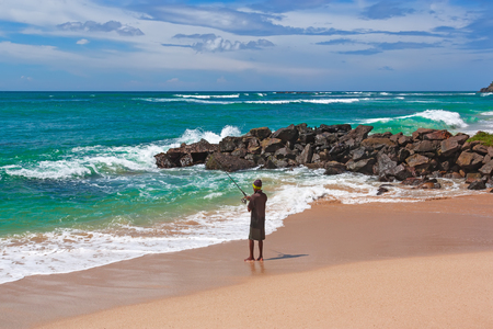 The fisherman catches fish from the seashore. Indian Ocean island of Sri Lanka.の写真素材