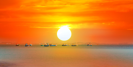Beautiful sunrise, tropical beach white sand, turquoise ocean water . Boats of fishermen on the water.の写真素材