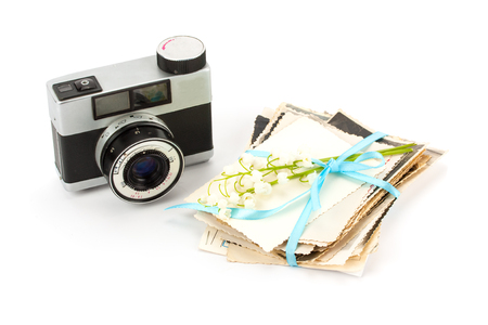 Vintage film photo-camera and old family photos isolated on white background.