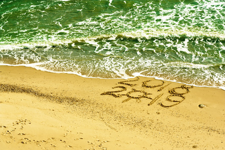 Tropical beach, turquoise waters of the ocean, symbols of the outgoing year and symbols of the new...