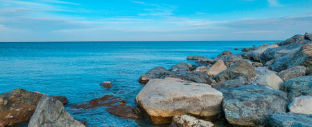 Panoramic view of big stones in the sea above blue sky. Coast of the Black Sea in Batumiの写真素材