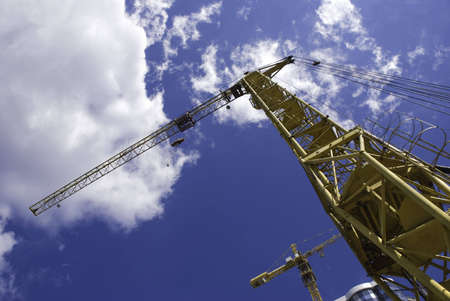 cranes and building on sky background, special photo f/x, focus point on nearest partof crane