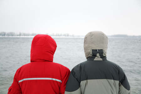 two people in jacket with hood on the river backgroundの写真素材