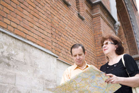 travelers (mature adult in in old Europe with map) focus point on faceの写真素材