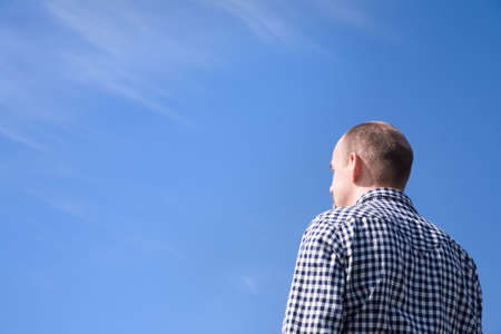 man on blue sky background with empty space for text or designの写真素材