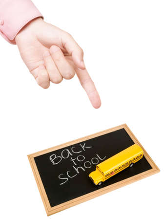concept with hand of teacher and blackboard with yellow bus isolated on white background