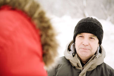 seniors on the walkway in snowy park, focus on eye of manの写真素材