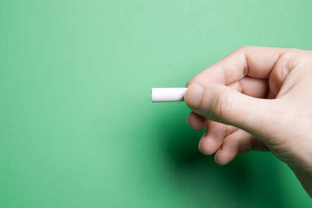educational concept selective focus on hand and piece of chalkの写真素材