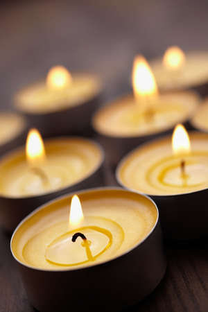 tea-lights on wooden table, selective focus on nearest の写真素材