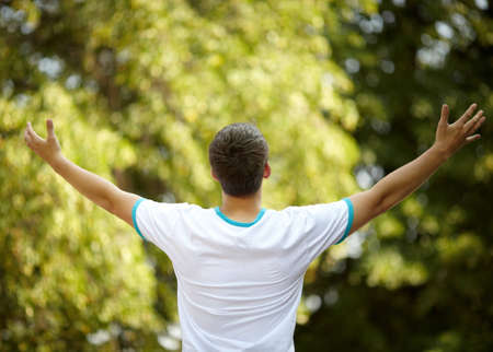 happy young man on nature background, selective focus, natural light の写真素材