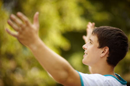 happy young adult on green foliage background, selective focusの写真素材