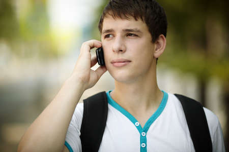 portrait of young man with cell-phone ,ambient light and silver reflectionの写真素材