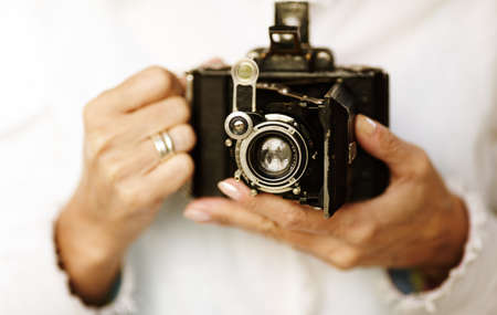 Woman hands with old film camera ,selective focus point on lens ,natural lightの写真素材