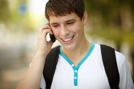 young man with cell-phone ,ambient light and silver reflection, focus on eyeの写真素材