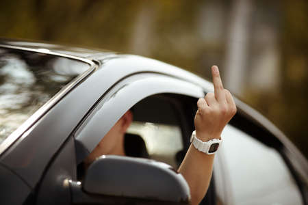 driver showing his middle fingerの写真素材