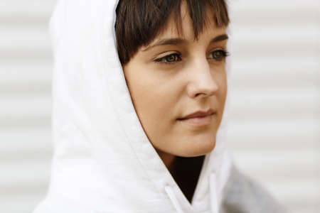 beautiful face of teen girl in white hood, selective focus on eyesの写真素材