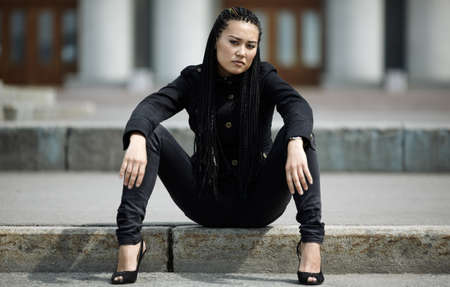 asian woman with black jeans, natural light, selective focus on faceの写真素材