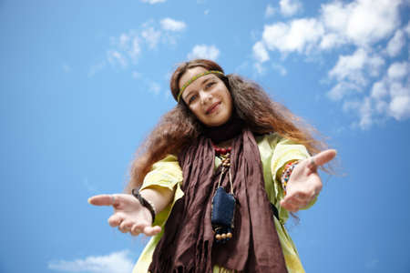 Hippie girl on blue sky background, sunny smileの写真素材