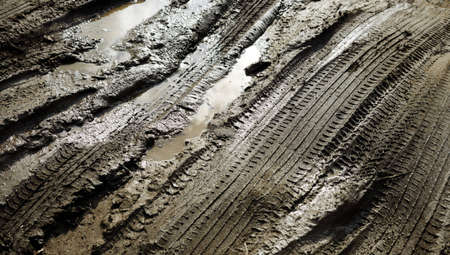 Tire patterns on the mud with reflection and water, selective focusの写真素材