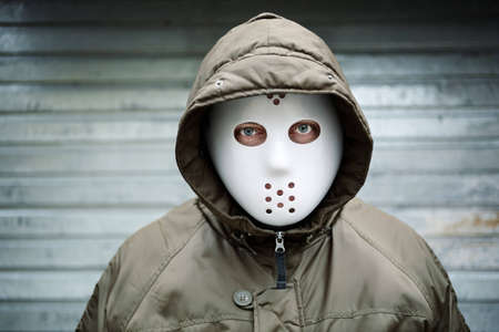 Spooky man with mask on the streetの写真素材