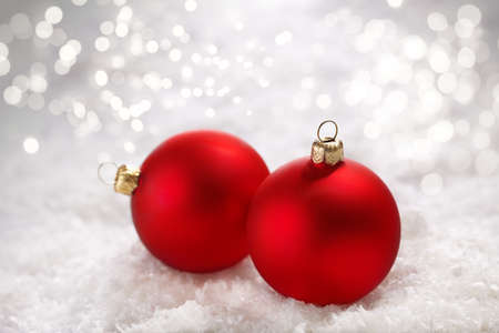 xmas red balls on  snow background with lights, selective focusの写真素材