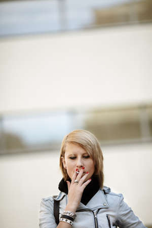real young woman smokes on the streetの写真素材
