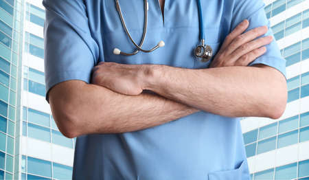 doctor with stethoscope in blue scrubsの写真素材